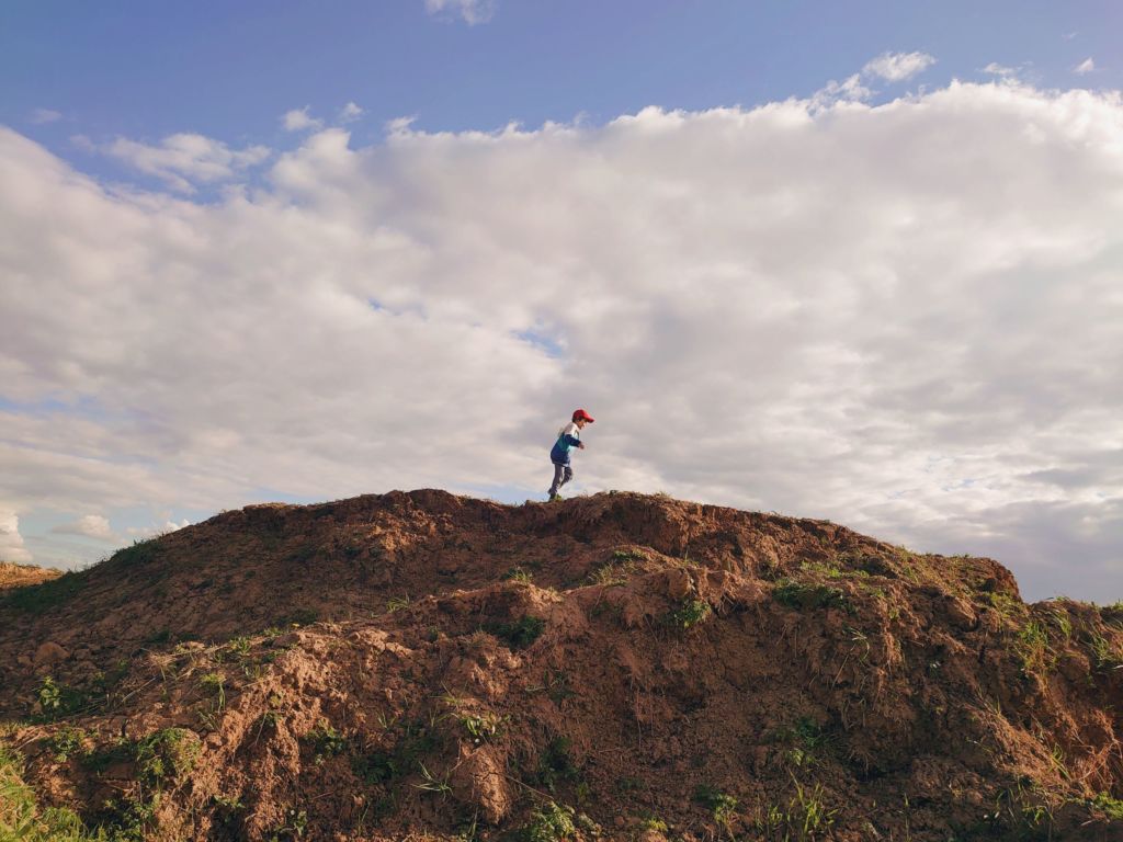 a tween child walking and hiking on the hill. summer wild nature landscape. mountain on the field.